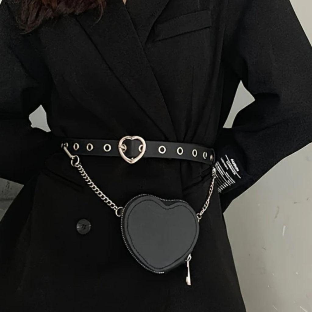 Person wearing a black coat with a heart-shaped black bag attached to a belt.
