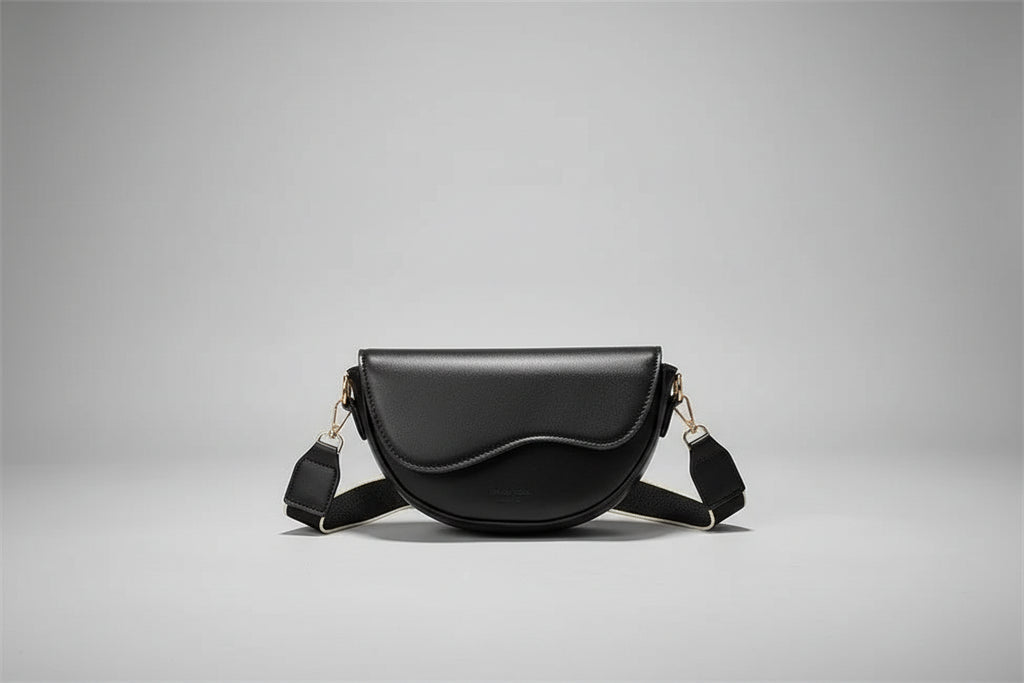 Black handbag held by a person with a box in the background