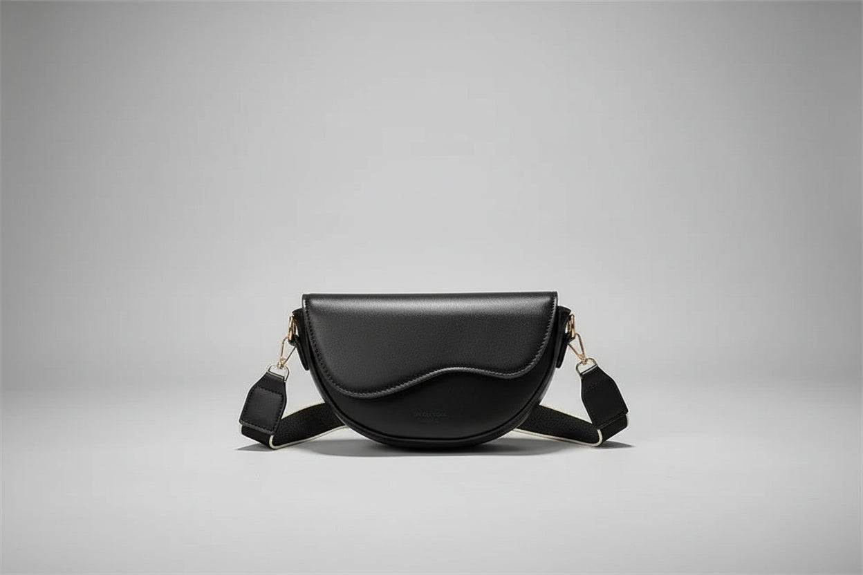 Black handbag held by a person with a box in the background